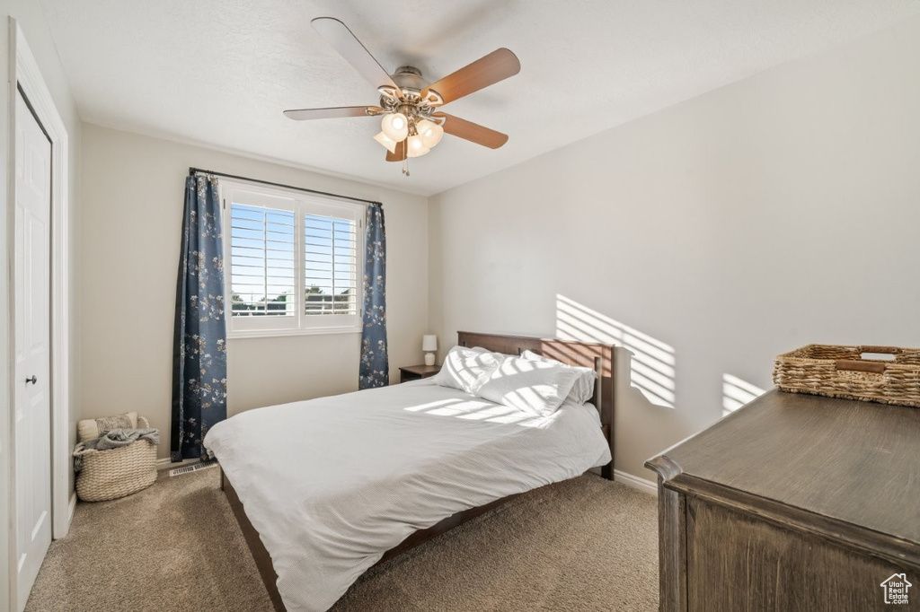 Bedroom with carpet, a closet, and a ceiling fan