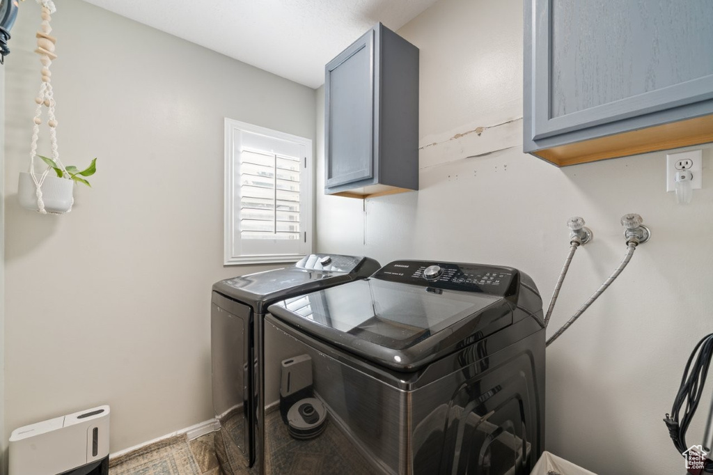 Washroom featuring cabinet space and washing machine and dryer