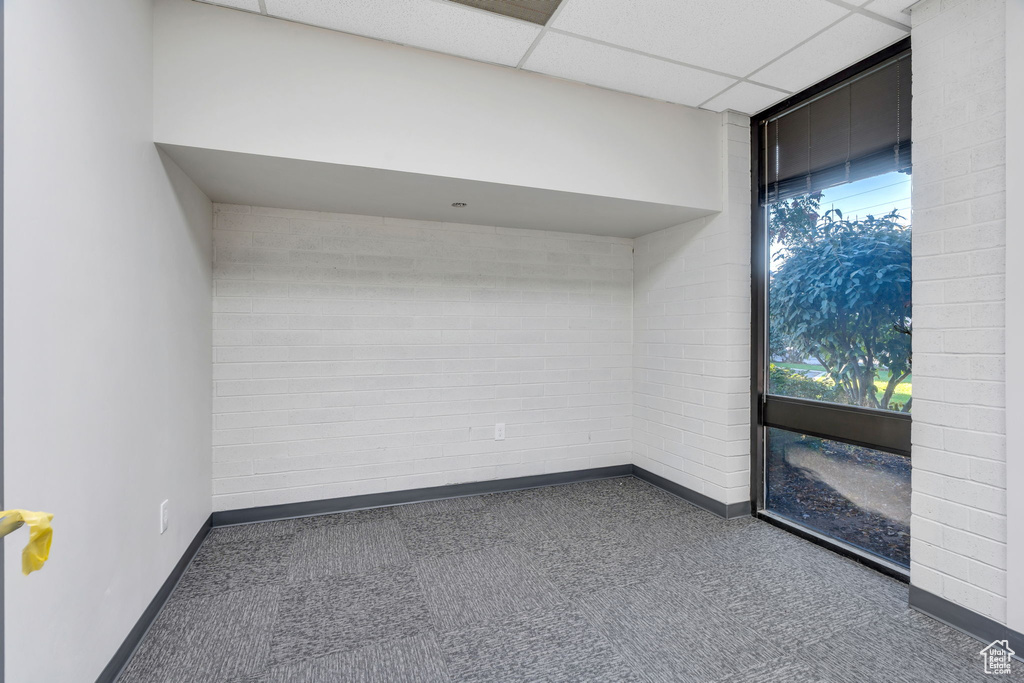 Unfurnished room featuring a paneled ceiling and tile patterned floors