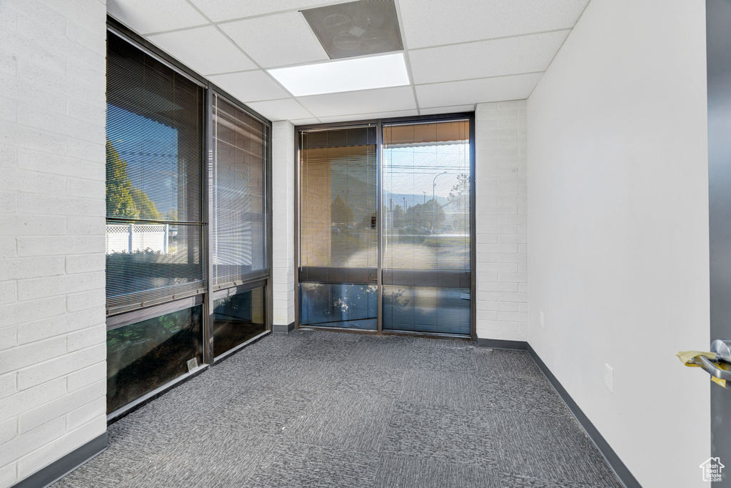 Unfurnished room with a paneled ceiling and floor to ceiling windows