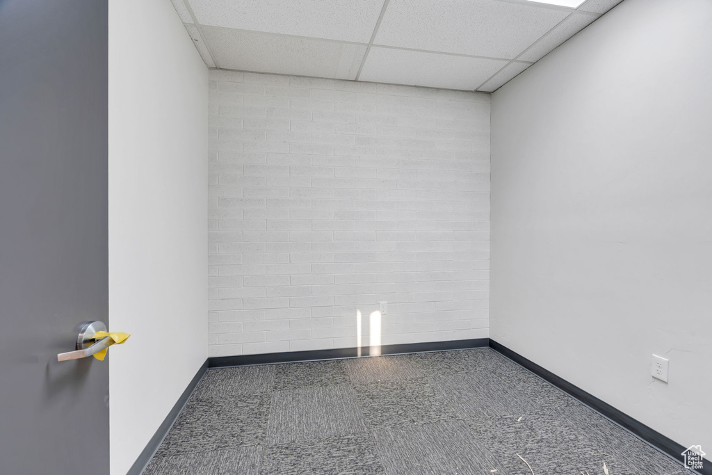 Empty room with a drop ceiling and baseboards
