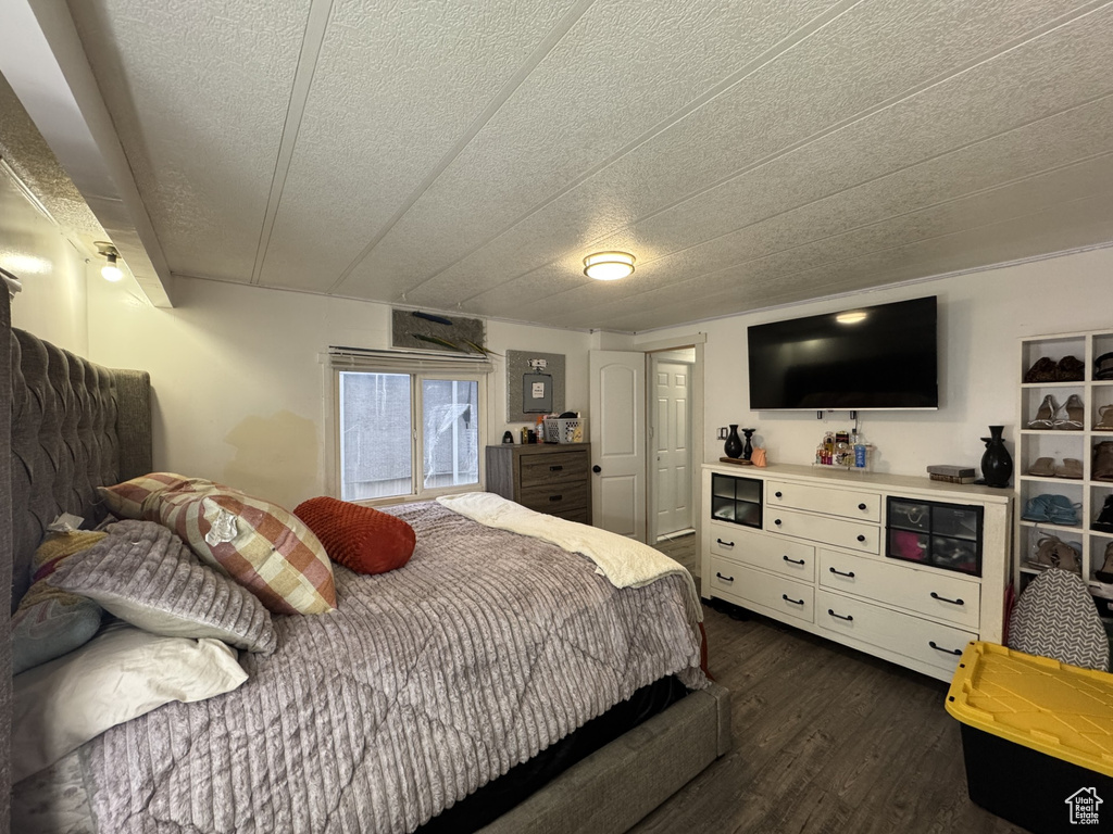 Bedroom with dark wood finished floors and a textured ceiling