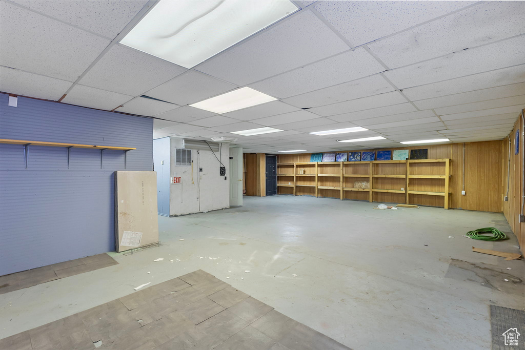 Below grade area featuring wood walls and a drop ceiling