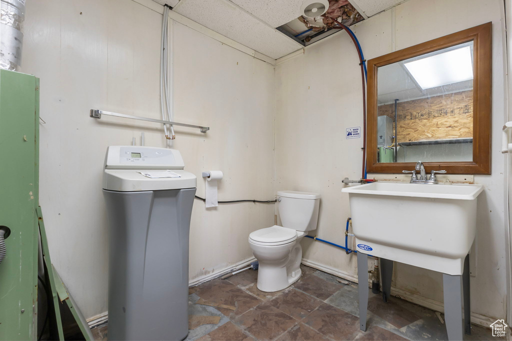 Bathroom featuring toilet and dark stone finish flooring