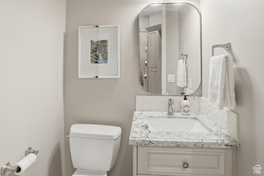 Half bathroom featuring vanity and toilet