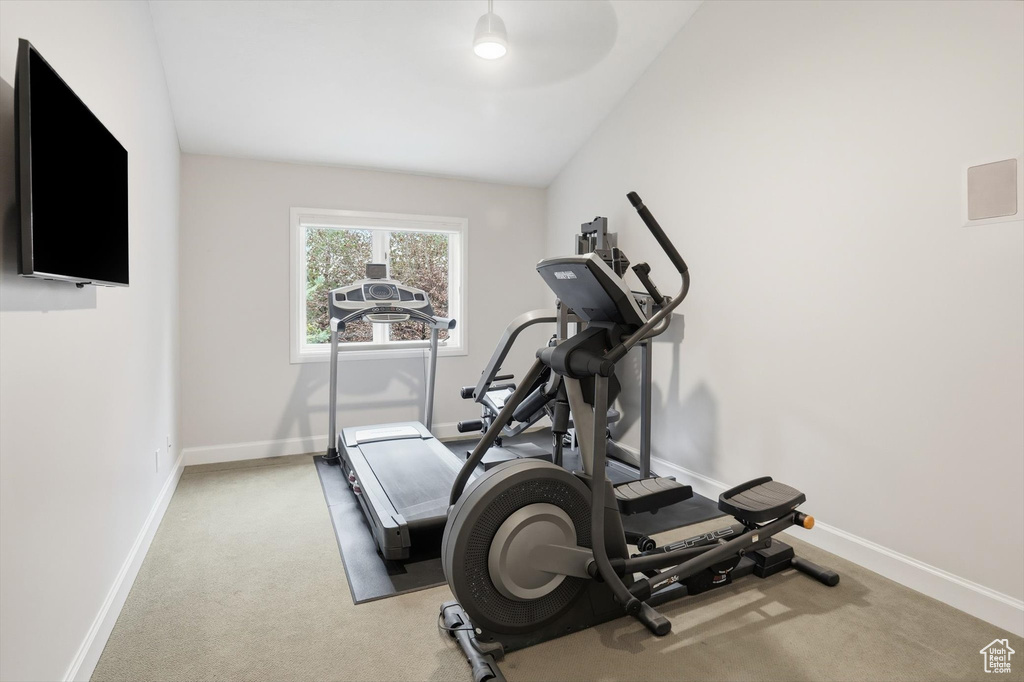 Exercise room with baseboards and light colored carpet