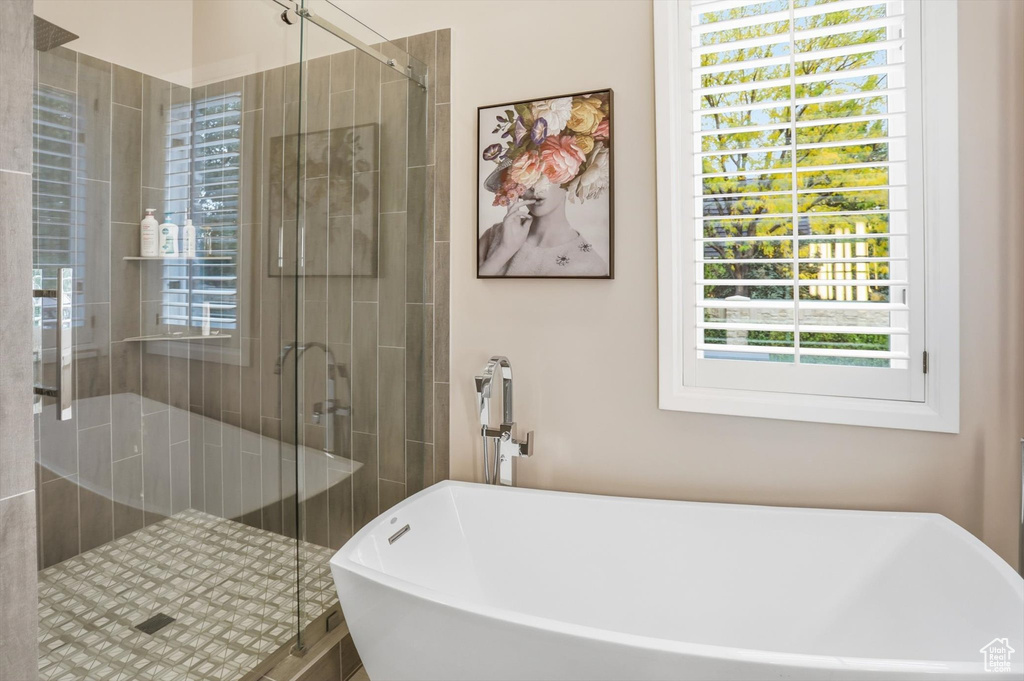 Bathroom with a shower stall and a soaking tub