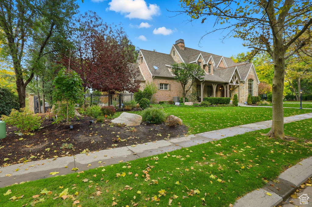 View of front facade featuring a chimney, a porch, and stone siding