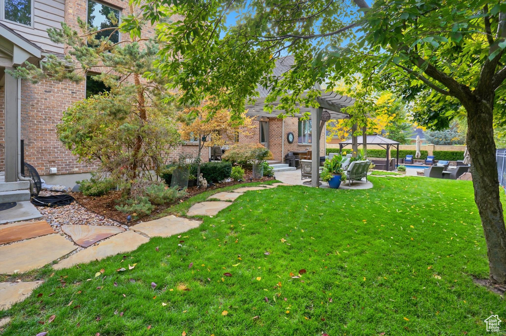 View of grassy yard featuring a gazebo, a patio, and outdoor lounge area