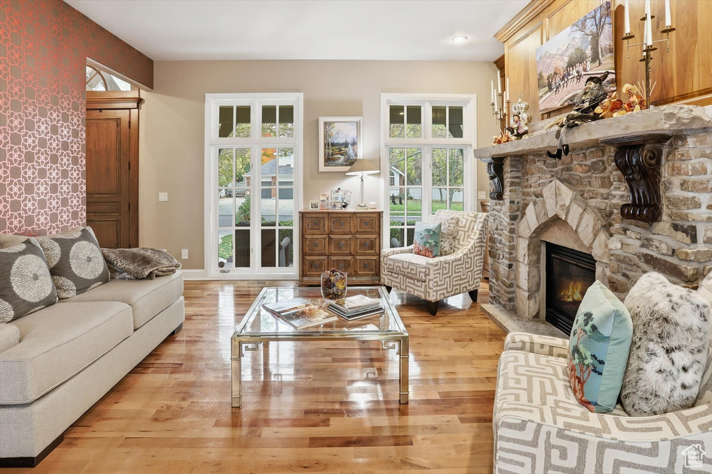 Living room with a stone fireplace and light wood finished floors