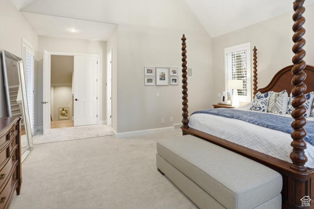 Bedroom with lofted ceiling and light colored carpet