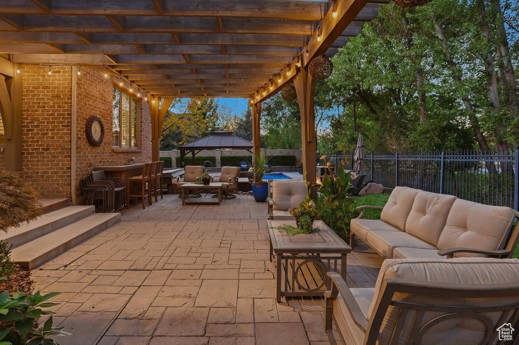 Fenced backyard with outdoor lounge area, a gazebo, a patio area, and outdoor dining space