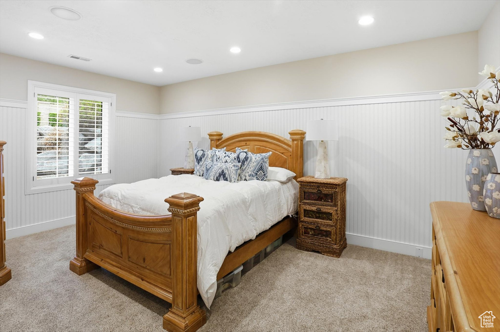 Bedroom featuring a wainscoted wall, recessed lighting, and light colored carpet