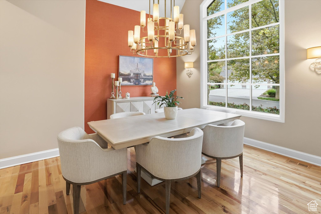 Dining space with light wood-style floors and a chandelier