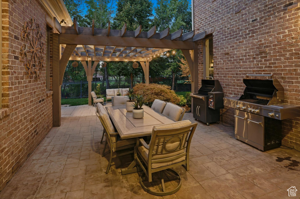 View of patio featuring a pergola, a grill, and outdoor dining area