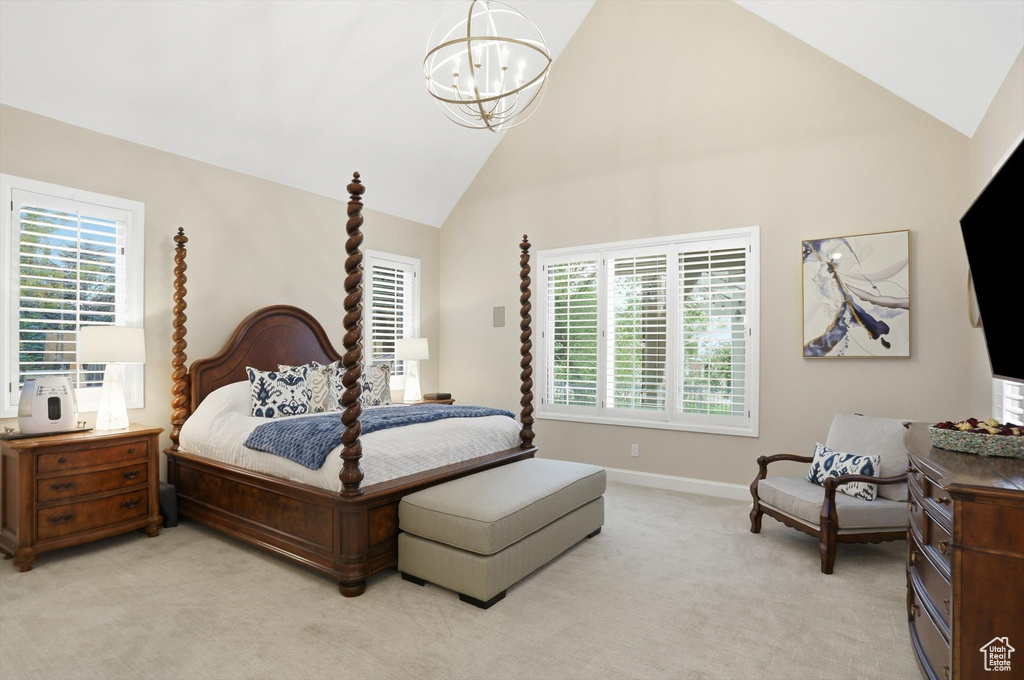 Carpeted bedroom with high vaulted ceiling and a chandelier