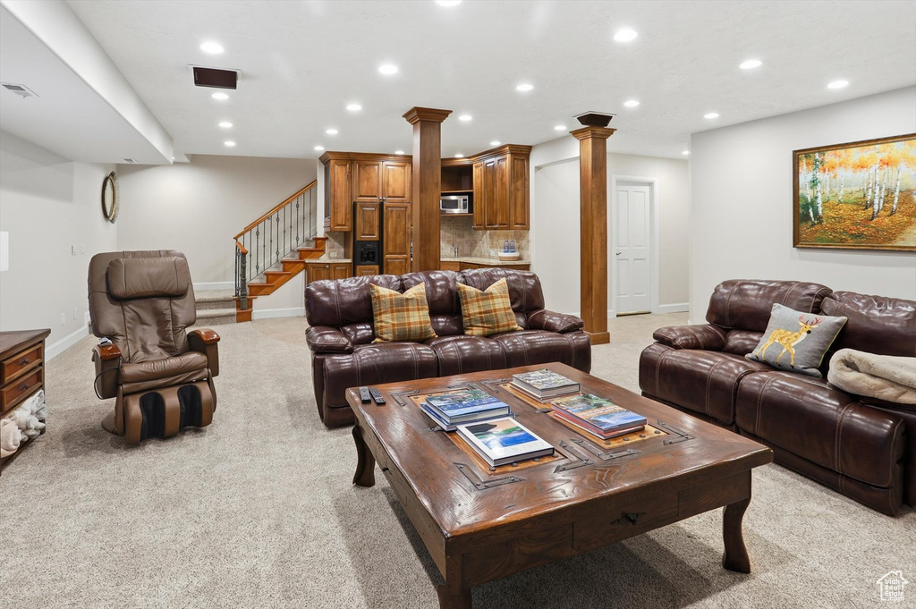 Living room with light carpet, recessed lighting, and stairway
