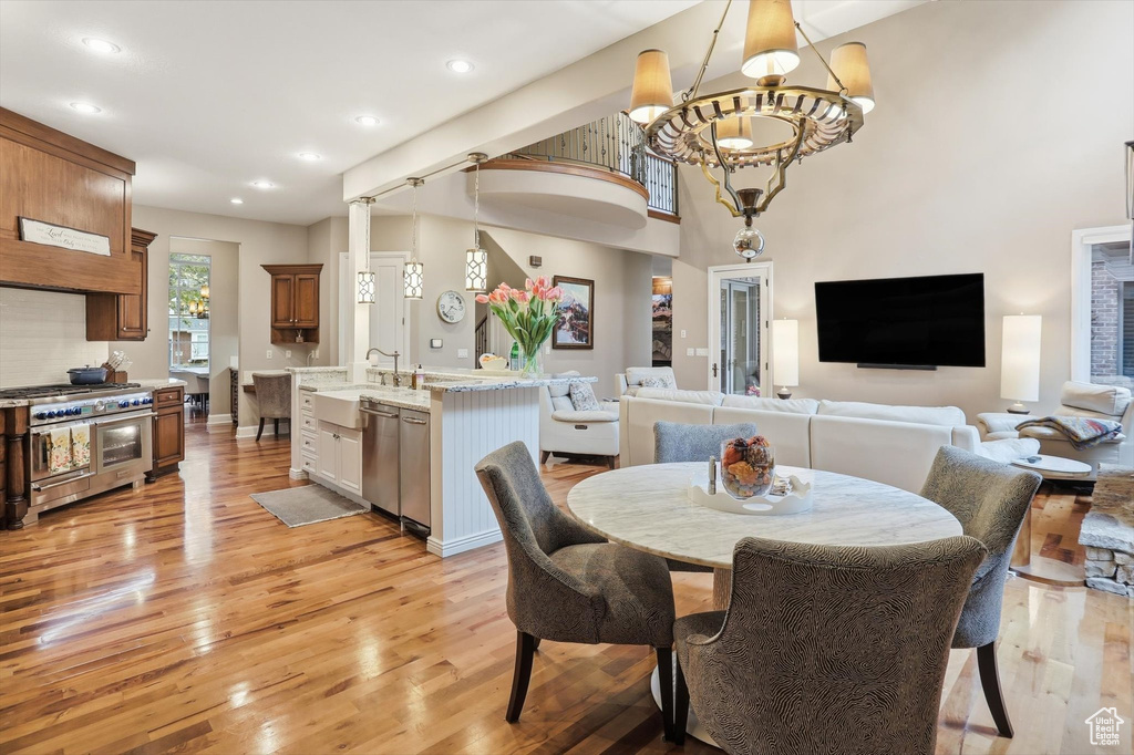 Dining room with light wood-type flooring, recessed lighting, and a chandelier