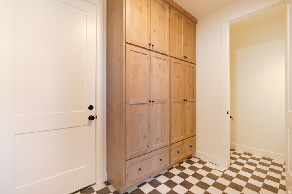 Mudroom featuring light flooring and baseboards