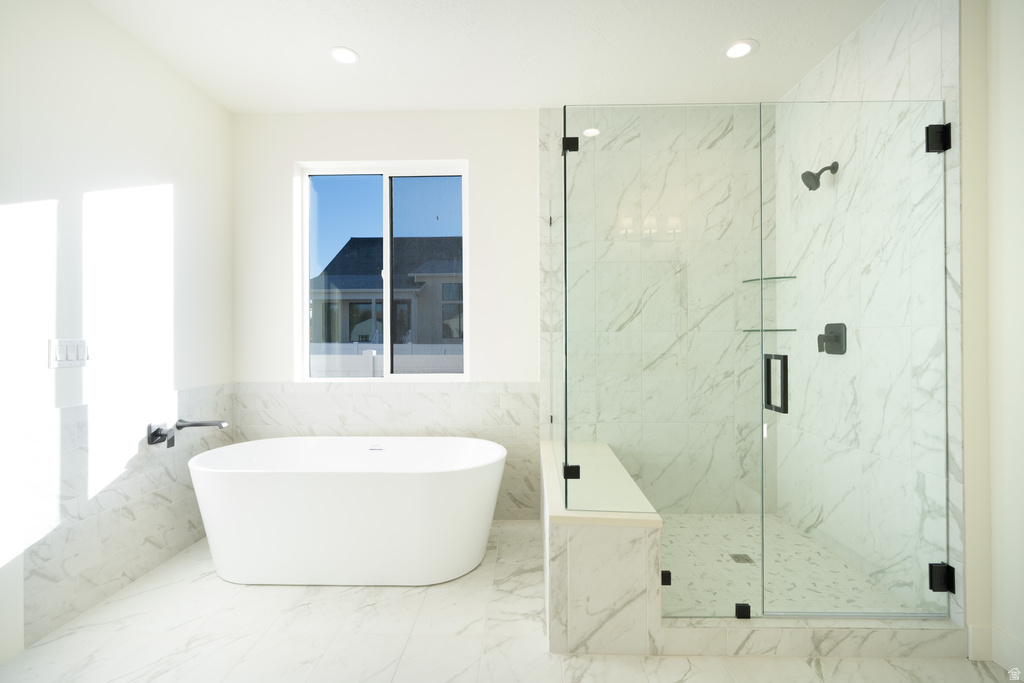 Bathroom featuring a soaking tub, tile walls, recessed lighting, a marble finish shower, and marble finish flooring