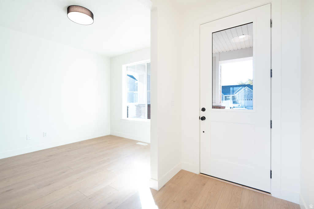 Foyer with light wood-style flooring and baseboards