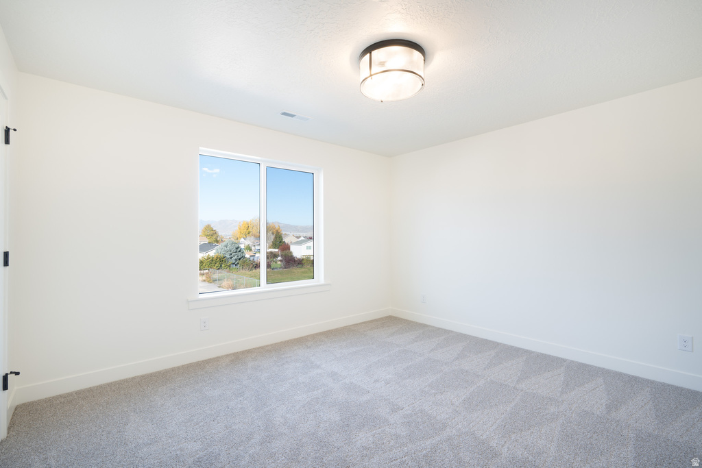 Carpeted empty room with baseboards