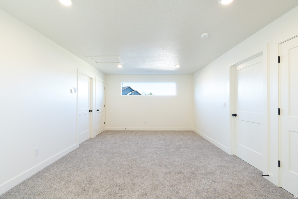 Spare room with attic access and light carpet