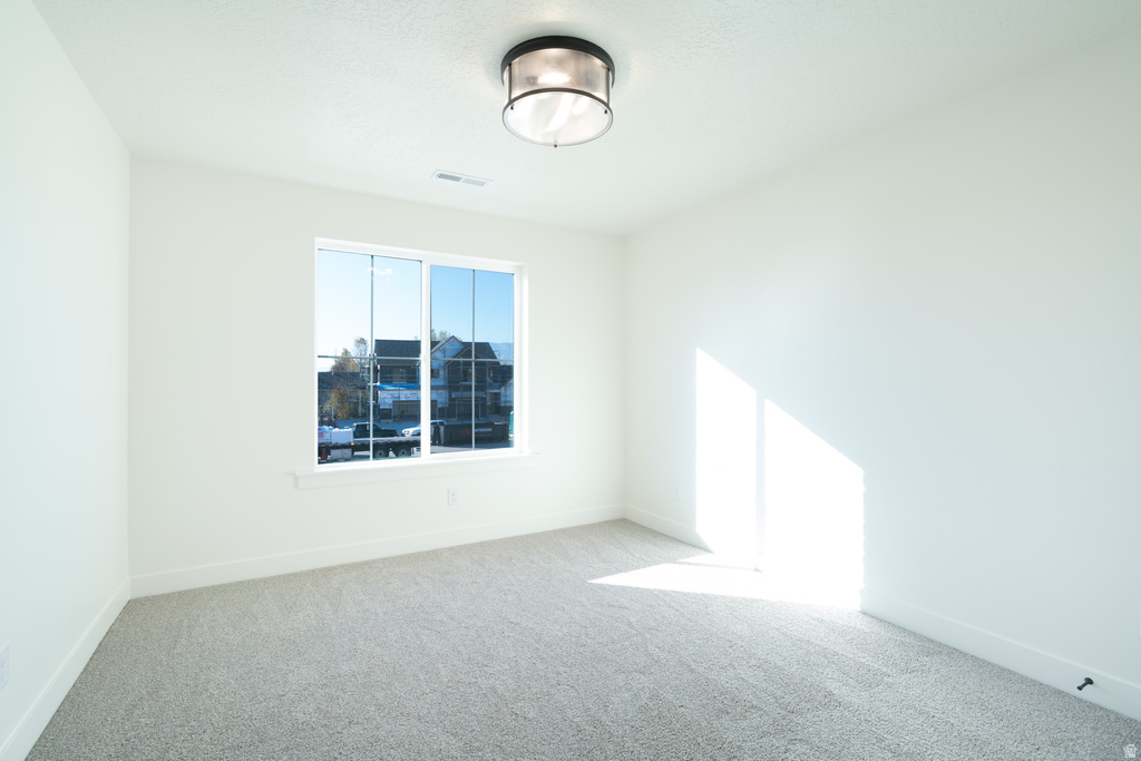 Spare room with light carpet and baseboards