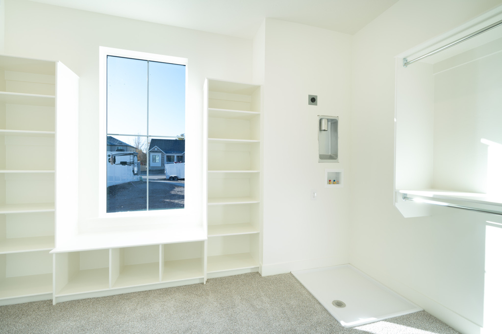 Spacious closet with light carpet