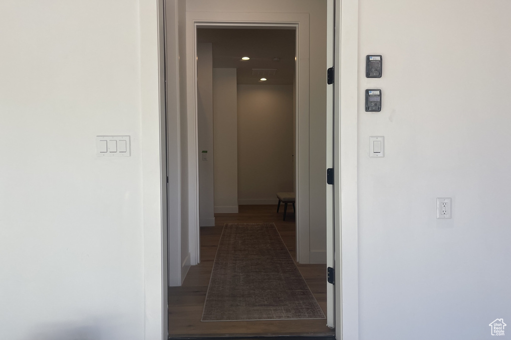 Hallway with dark wood-style flooring and recessed lighting