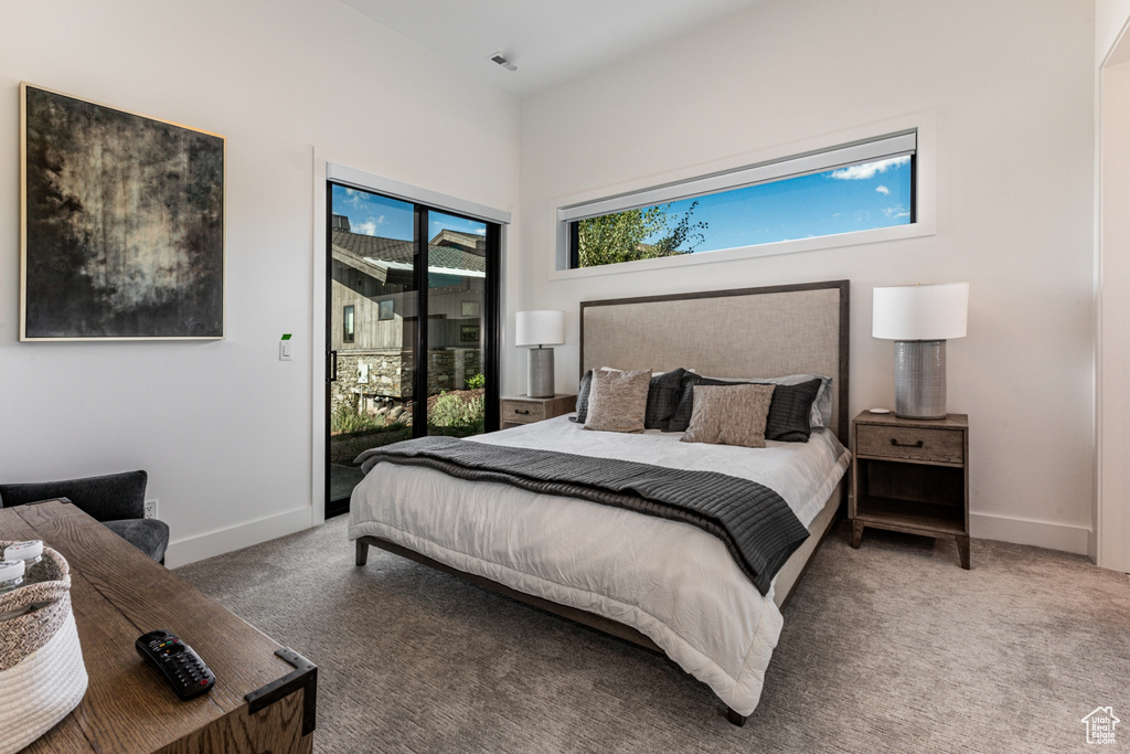 Carpeted bedroom with access to outside and baseboards