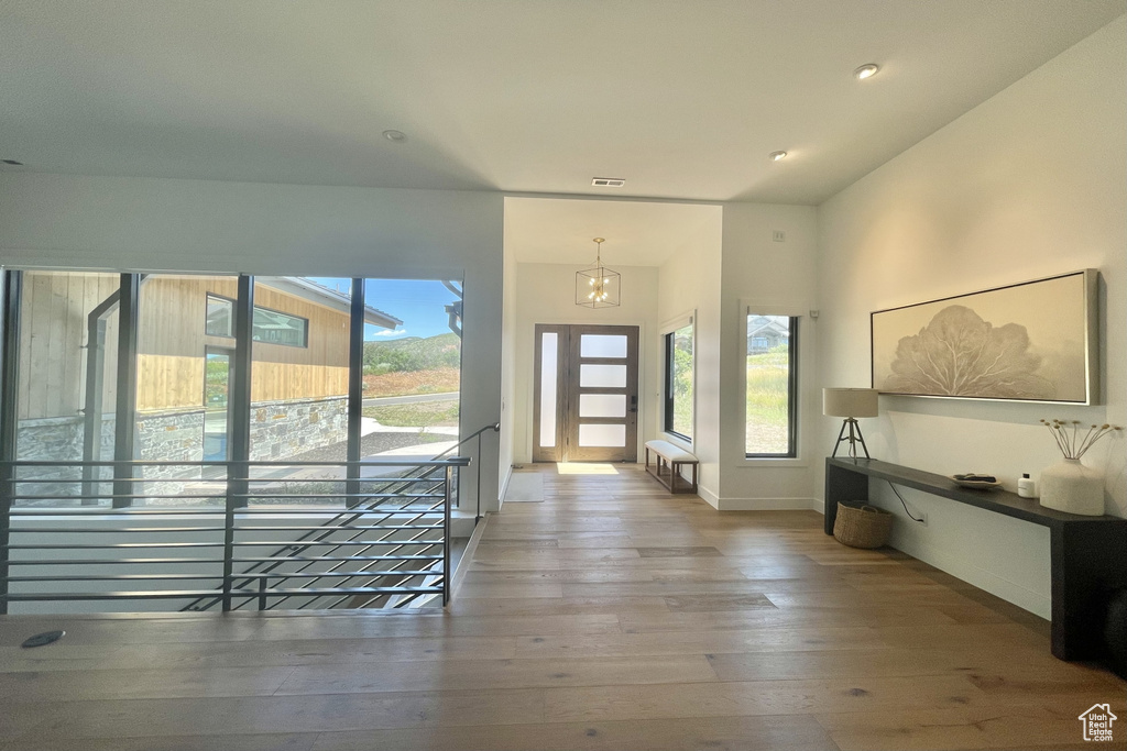 Entrance foyer with a chandelier, light wood-style floors, and recessed lighting