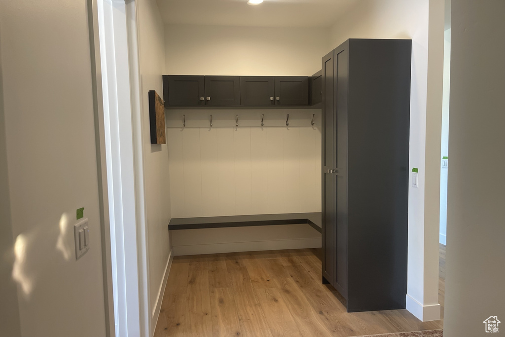 Mudroom featuring light wood finished floors and baseboards