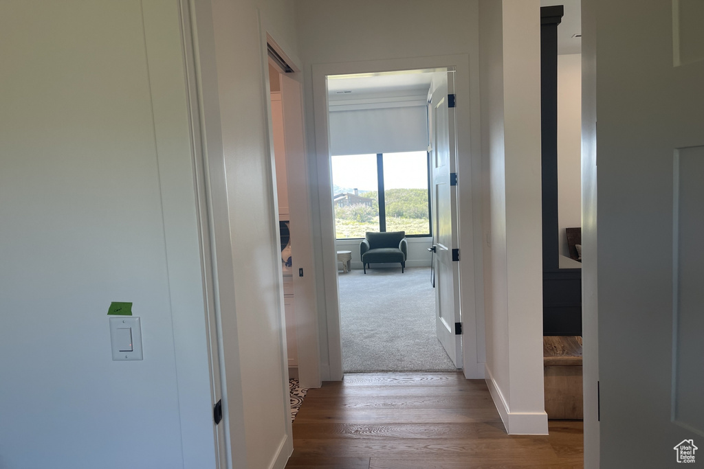 Corridor with wood finished floors and baseboards
