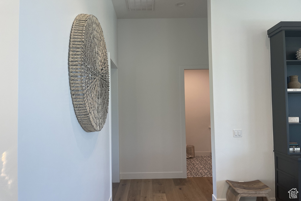 Hallway with light wood-style floors and baseboards