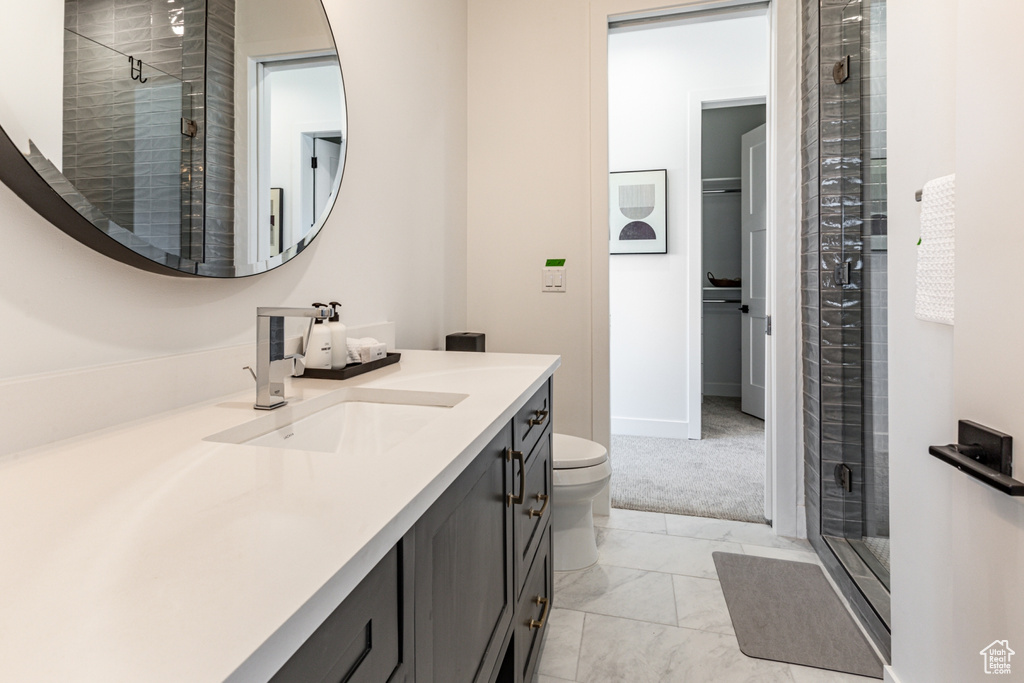 Bathroom with a stall shower, vanity, and a walk in closet
