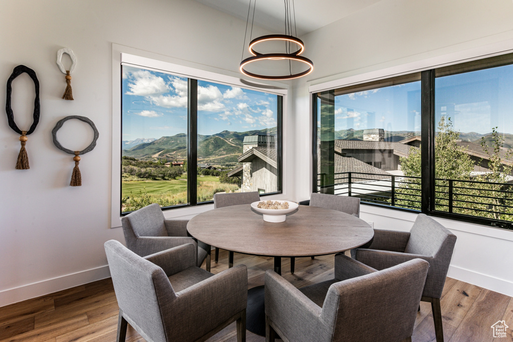 Dining space with a mountain view, wood finished floors, and a chandelier