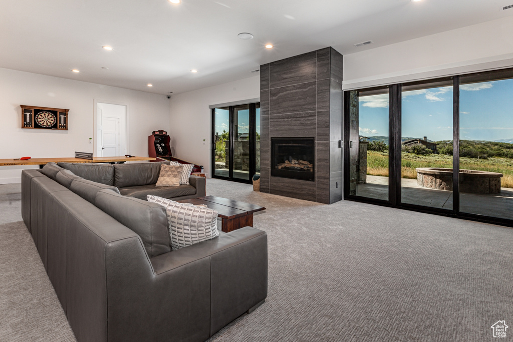 Living room featuring recessed lighting, light carpet, and a fireplace