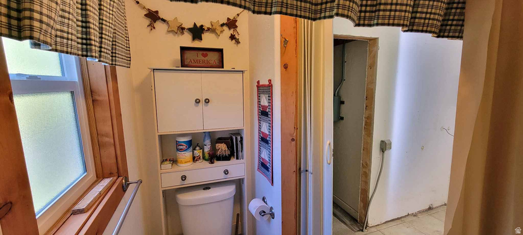 Half bathroom with toilet and tile patterned flooring