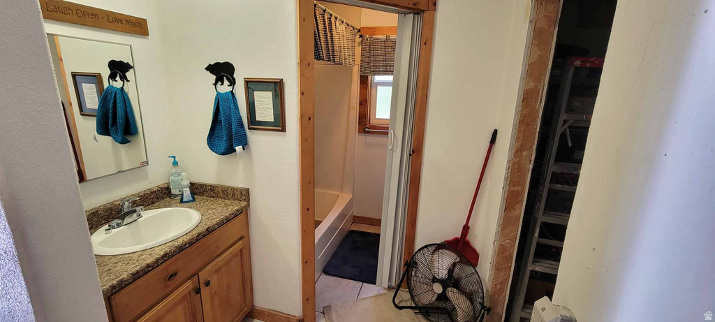 Bathroom featuring vanity, a shower, and light tile patterned floors