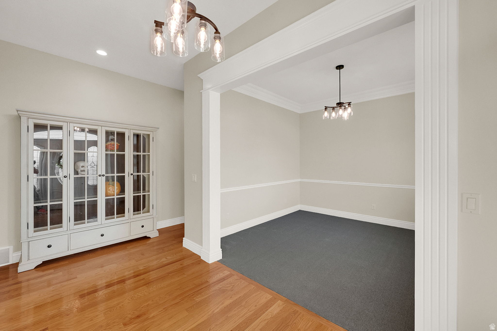 Unfurnished dining area with a chandelier, wood finished floors, and recessed lighting