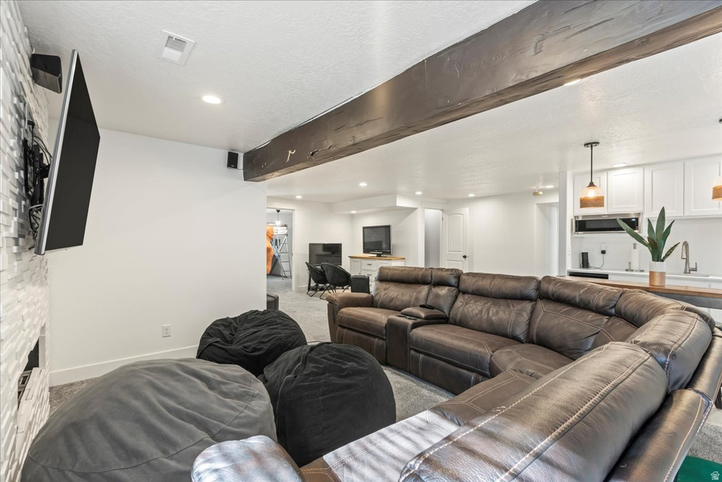 Living room with beam ceiling, carpet, recessed lighting, and a textured ceiling