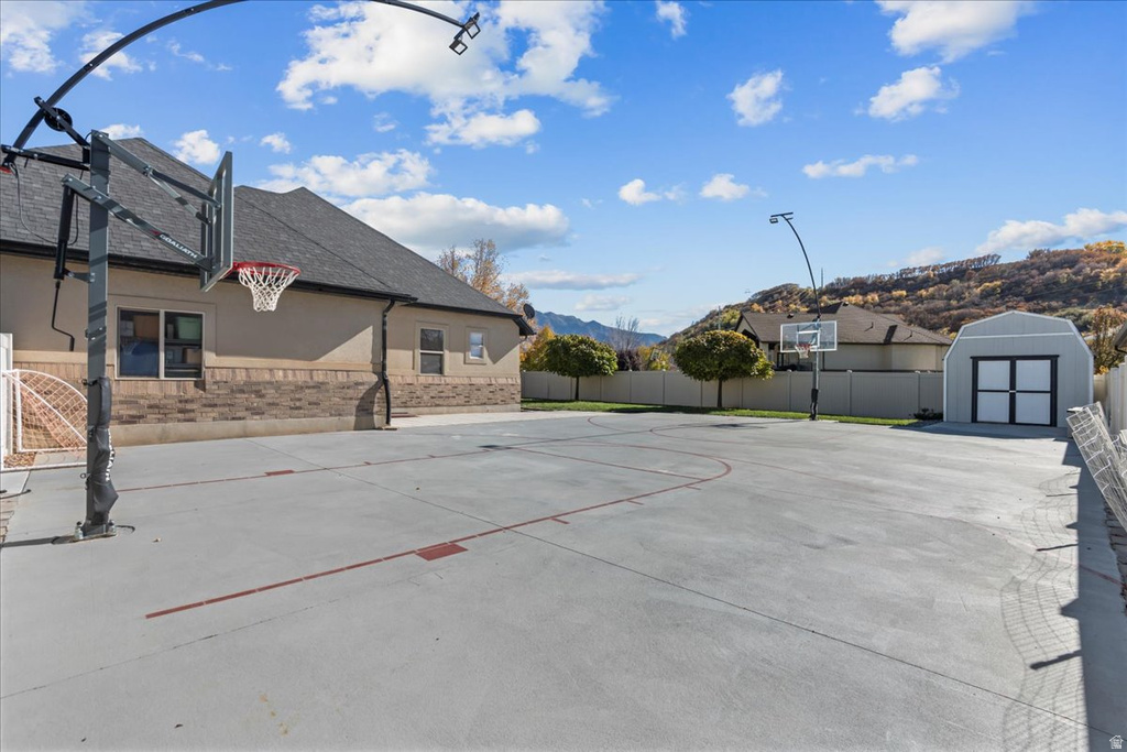 View of sport court featuring community basketball court, a mountain view, and a shed