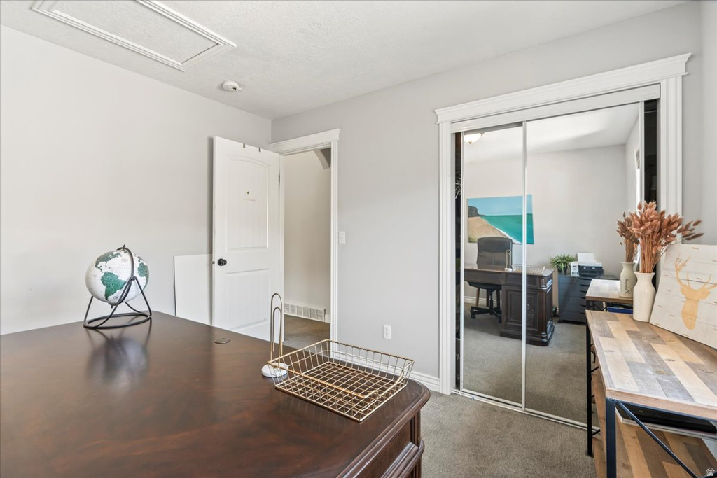 Office area featuring dark carpet and baseboards