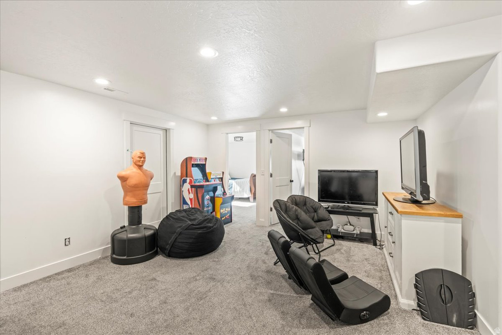 Living area featuring light carpet, recessed lighting, and a textured ceiling