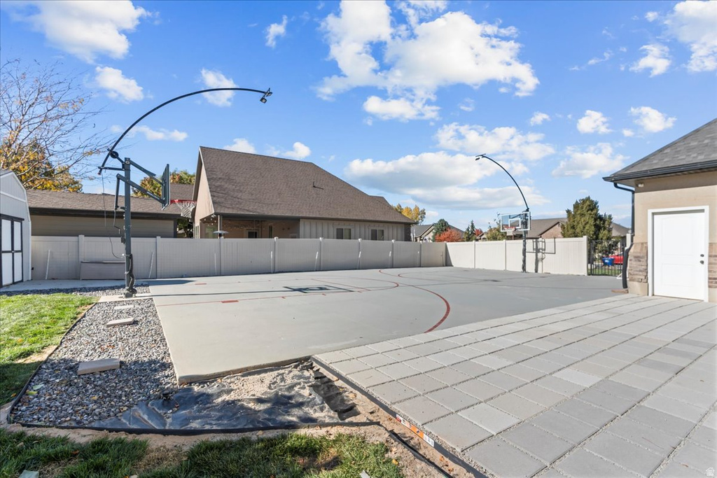 View of basketball court with a fenced backyard and basketball court