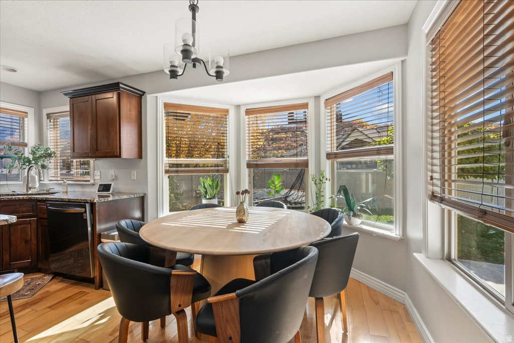 Dining area with light wood-style floors and a chandelier