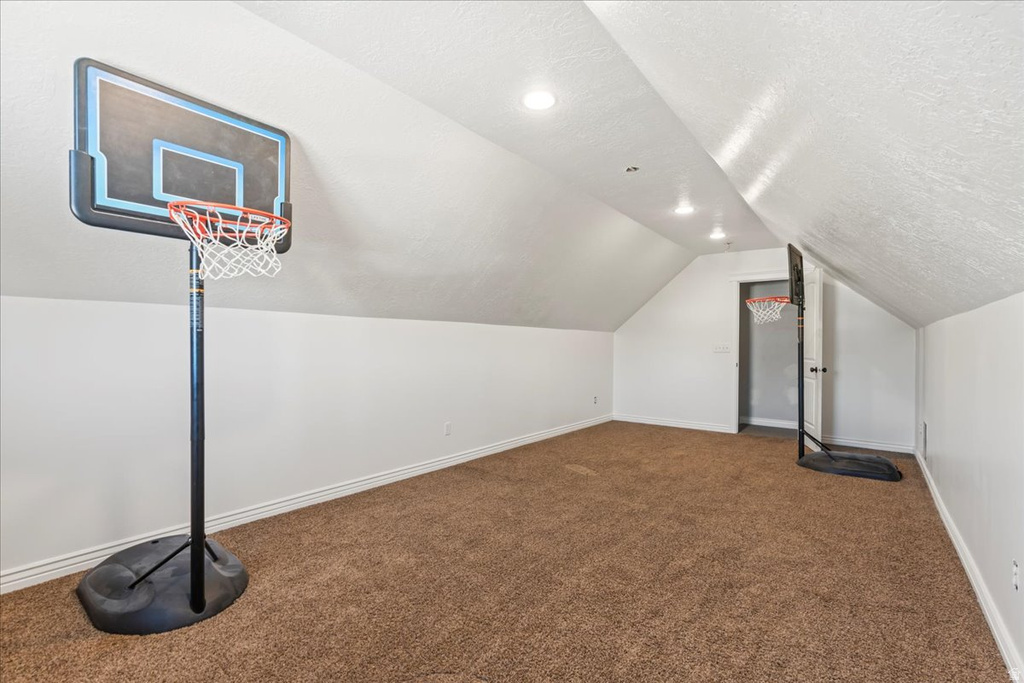 Bonus room featuring carpet, a textured ceiling, vaulted ceiling, and recessed lighting