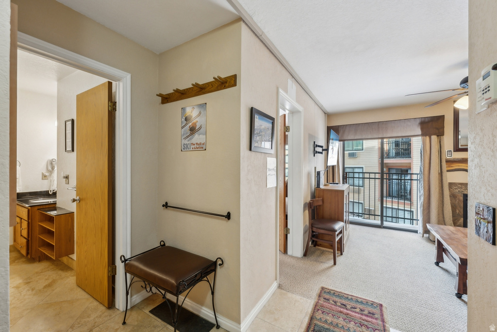 Hallway featuring light carpet and light tile patterned floors