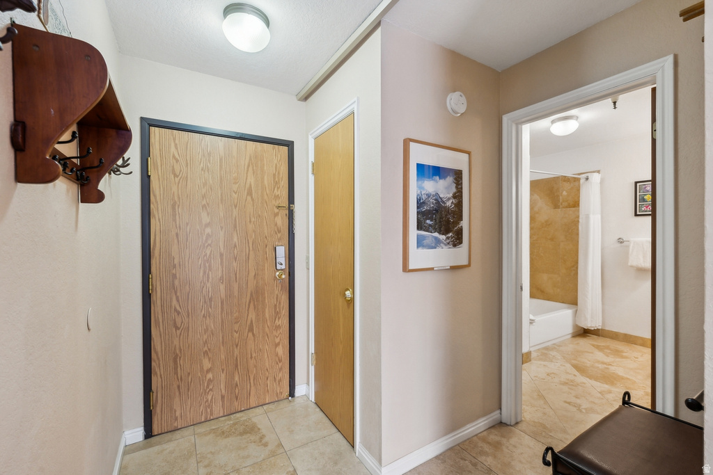 Hallway featuring light tile patterned floors and baseboards